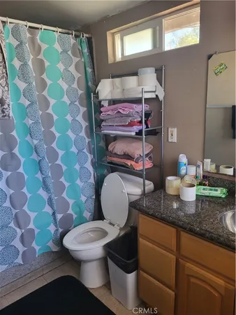 a bathroom with a granite countertop toilet sink and mirror