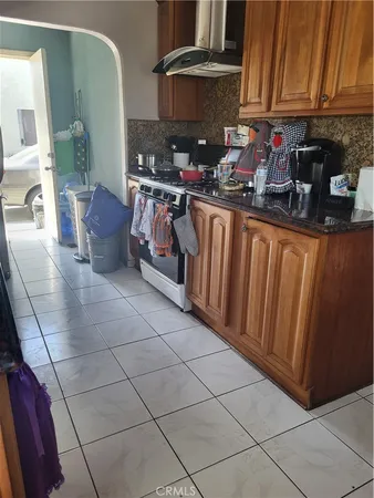 a kitchen with stainless steel appliances a sink a stove a microwave cabinets and a dining table