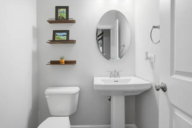 a bathroom with a toilet sink and mirror