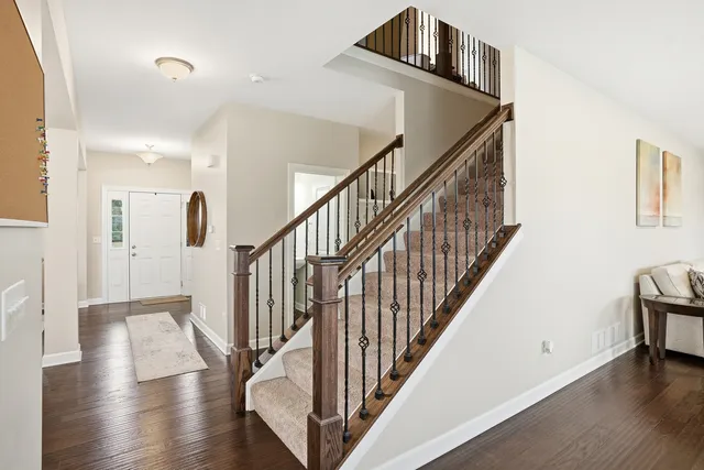 a view of staircase with lots of frames on wall and wooden floor