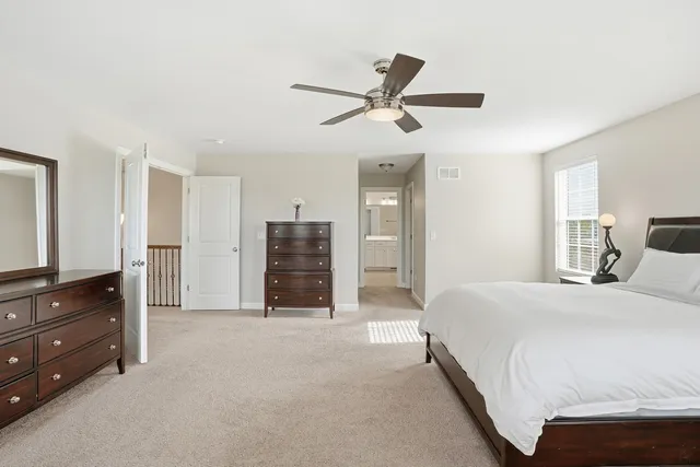 a spacious bedroom with a bed and a dresser