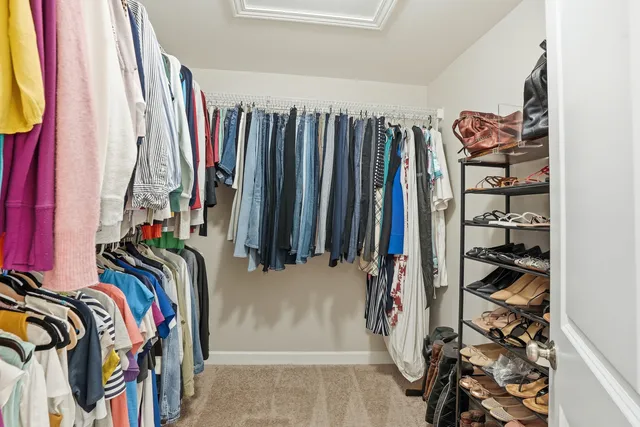 a view of walk in closet with clothes and shoes