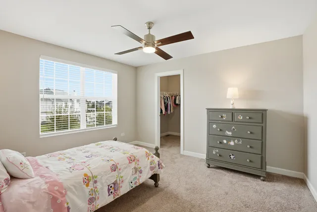 a bedroom with a bed a dresser and a window