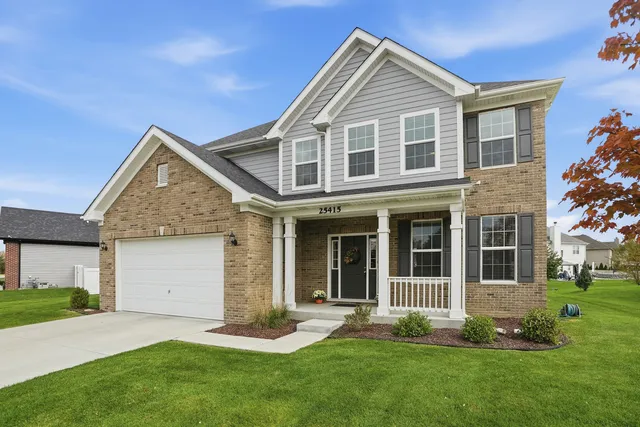 a front view of a house with a garden and yard
