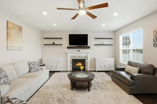 a living room with furniture a flat screen tv and a fireplace