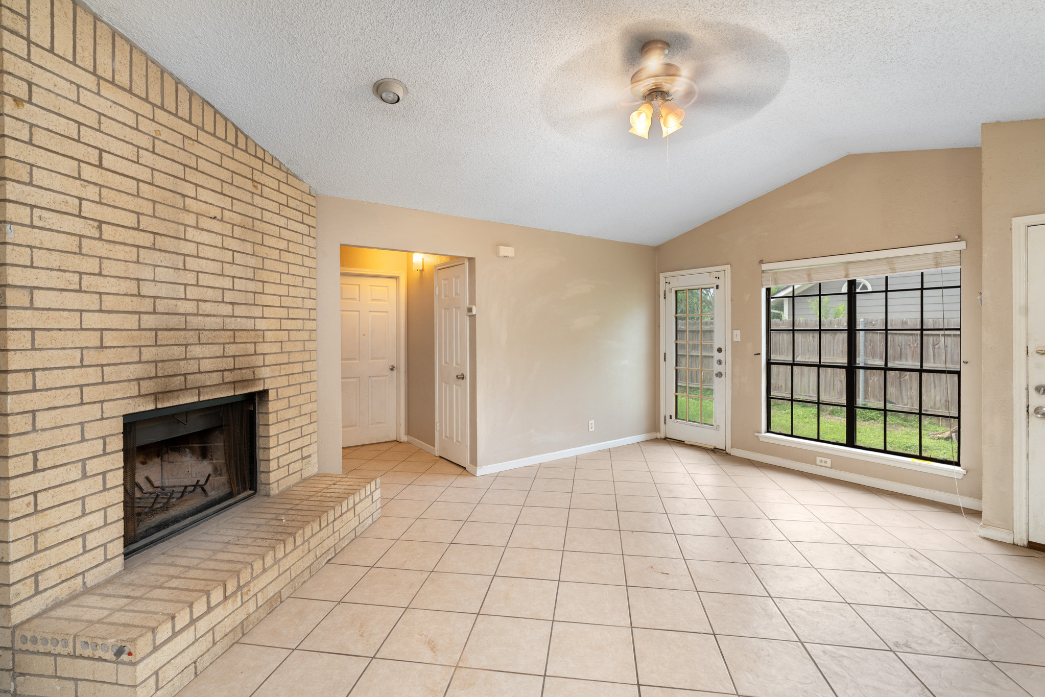 8703 Clearbrook Trail Austin, TX 78729 - Photo 4 of 9 a view of an empty room with a fireplace and a window