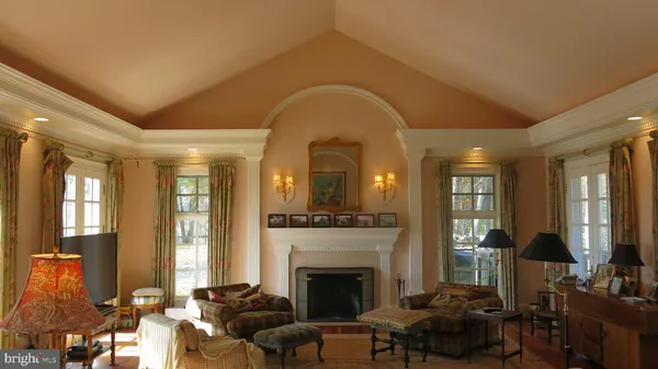 a living room with furniture fireplace and a large window