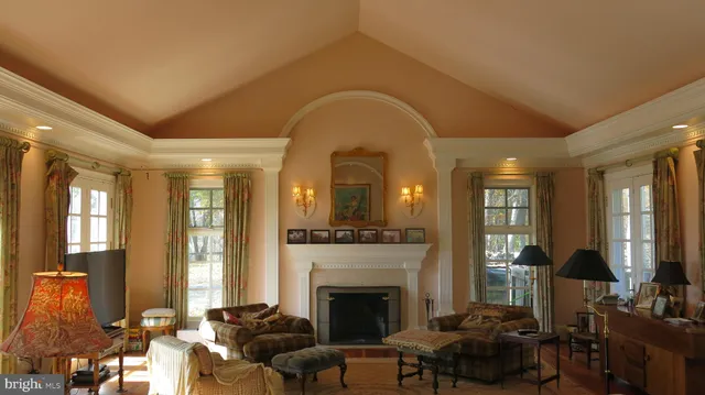 a living room with furniture fireplace and a large window