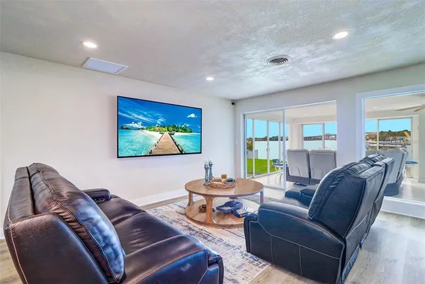 a living room with furniture a window and a flat screen tv