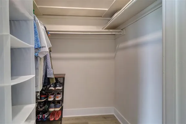 a view of walk in closet with clothes and shoes