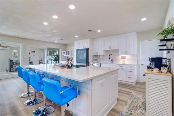 a large kitchen with cabinets a table and chairs