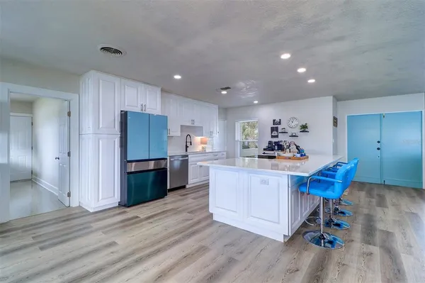 a view of kitchen with refrigerator microwave and wooden floor