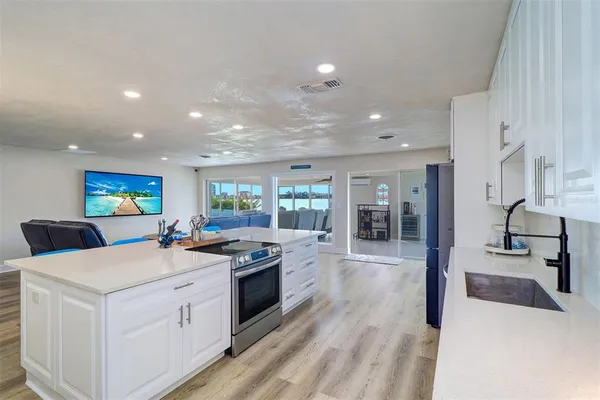 a kitchen that has a sink a stove and chairs