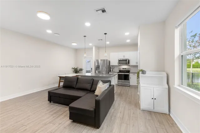 a living room with furniture and kitchen view
