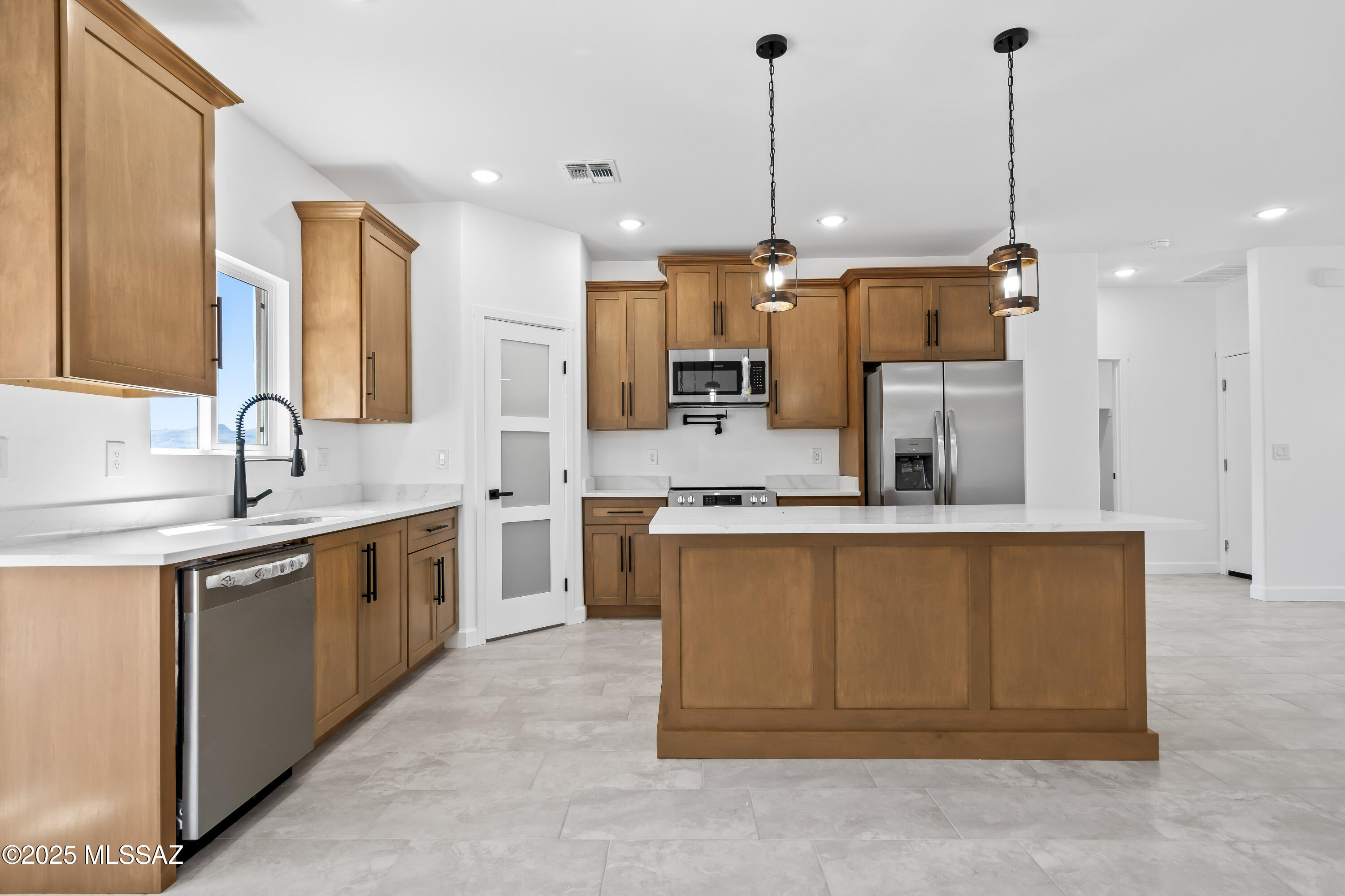 1667 Ave Calamar Rio Rico, AZ 85648 - Photo 10 of 33 a large kitchen with stainless steel appliances kitchen island granite countertop a sink a stove and a refrigerator