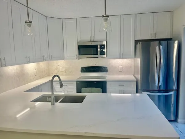 a kitchen with a refrigerator sink and microwave