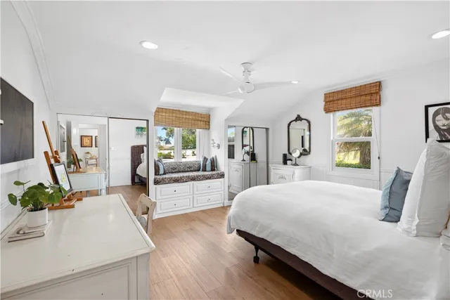 a bedroom with a bed large window and flat screen tv