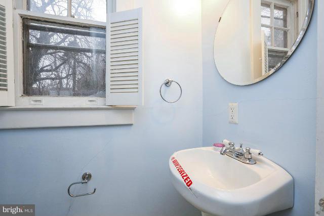 8402 Liberty Road Baltimore, MD 21244 - Photo 2 of 26 a bathroom with a sink and mirror with toilet