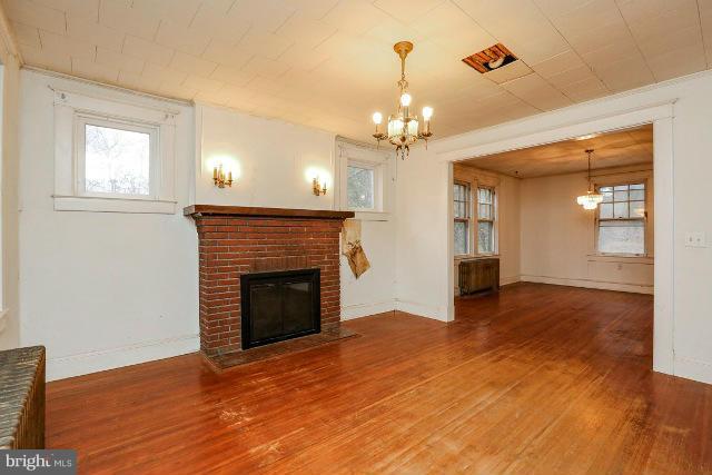 8402 Liberty Road Baltimore, MD 21244 - Photo 17 of 26 a view of an empty room with wooden floor fireplace and a window