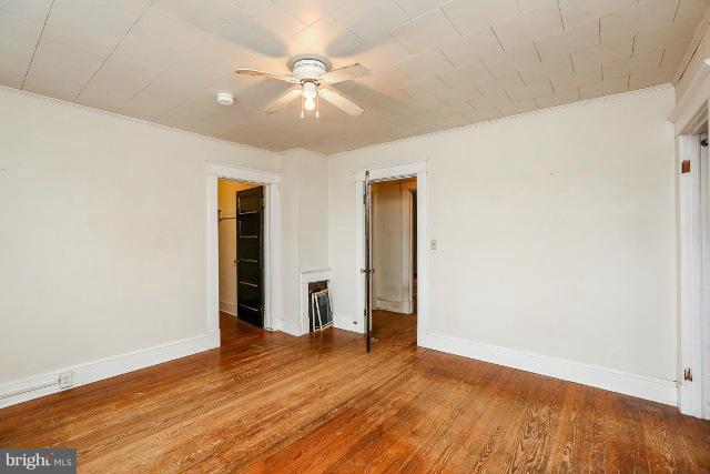 8402 Liberty Road Baltimore, MD 21244 - Photo 5 of 26 an empty room with wooden floor and fan