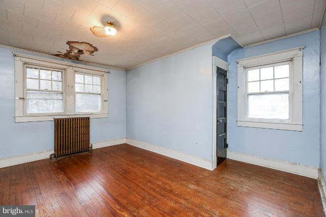 8402 Liberty Road Baltimore, MD 21244 - Photo 10 of 26 an empty room with wooden floor chandelier and windows