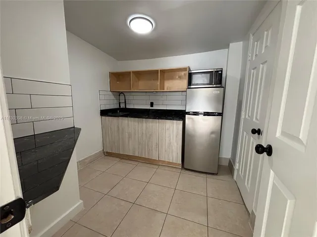 a kitchen with a refrigerator and cabinets