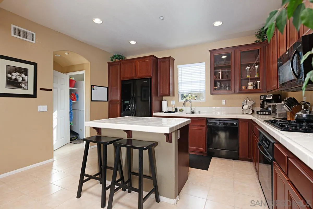 2248 Huntington Point Road, Unit 80 Chula Vista, CA 91914 - Photo 14 of 31 a kitchen with a table chairs refrigerator and cabinets