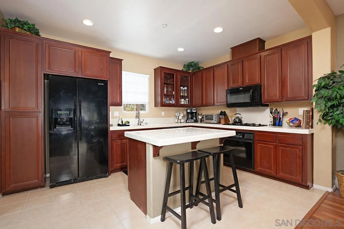 2248 Huntington Point Road, Unit 80 Chula Vista, CA 91914 - Photo 15 of 31 a kitchen with stainless steel appliances granite countertop a table chairs sink refrigerator and cabinets