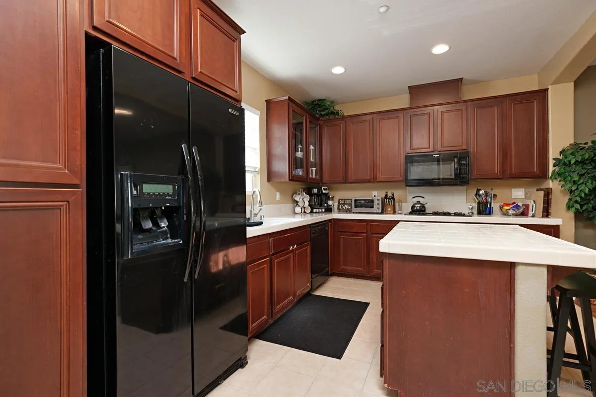 2248 Huntington Point Road, Unit 80 Chula Vista, CA 91914 - Photo 16 of 31 a kitchen with stainless steel appliances granite countertop a refrigerator a stove a sink and a oven with wooden cabinets