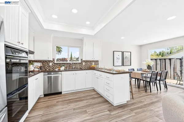 a kitchen with granite countertop cabinets stainless steel appliances dining table and chairs