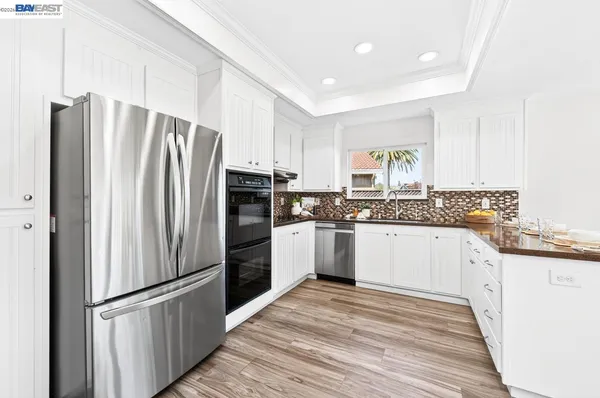 a kitchen with stainless steel appliances a refrigerator sink and cabinets