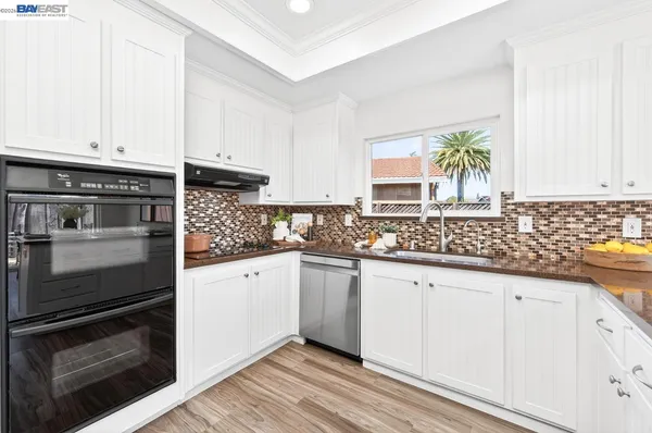 a kitchen with granite countertop white cabinets and stainless steel appliances
