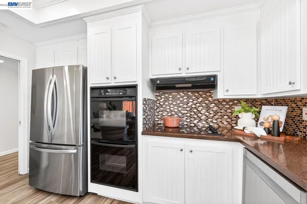 a kitchen with stainless steel appliances granite countertop a refrigerator and a stove
