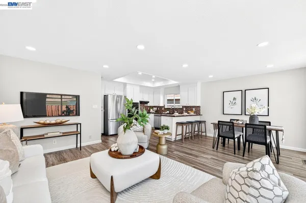 a living room with furniture kitchen view and a flat screen tv