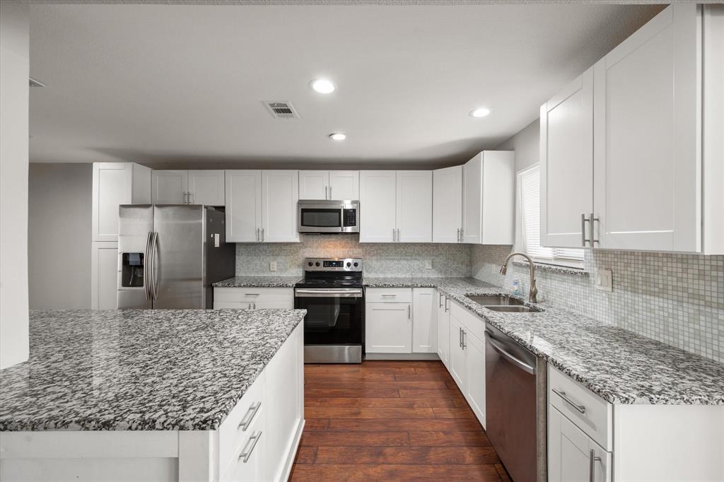 207 East Harwood Road, Unit 10 Euless, TX 76039 - Photo 13 of 34 a kitchen with stainless steel appliances granite countertop a sink stove microwave and refrigerator