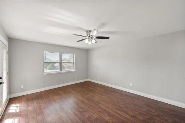 an empty room with a ceiling fan and a window