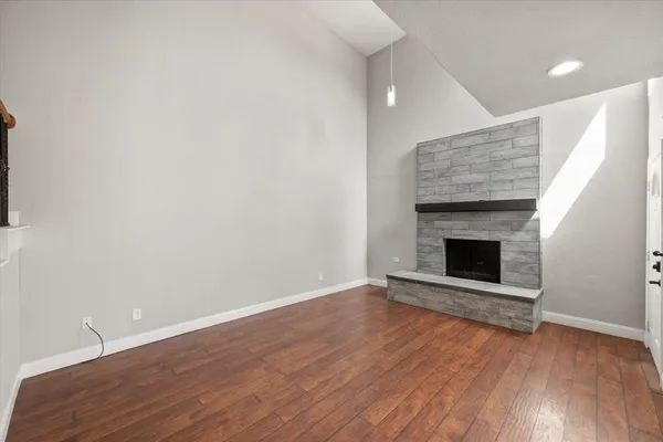 an empty room with wooden floor and fireplace
