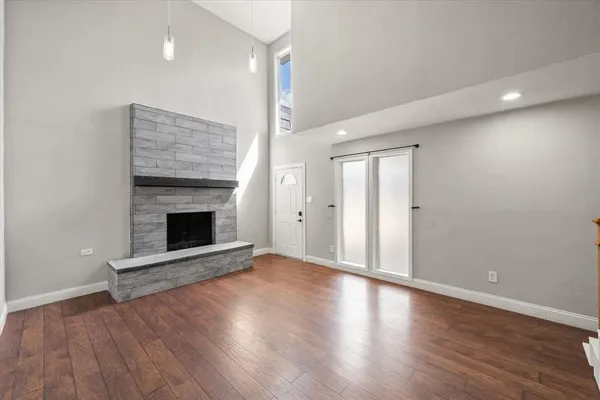 an empty room with wooden floor and fireplace