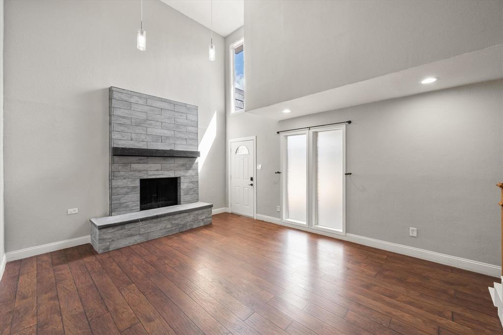207 East Harwood Road, Unit 10 Euless, TX 76039 - Photo 3 of 34 an empty room with wooden floor and fireplace