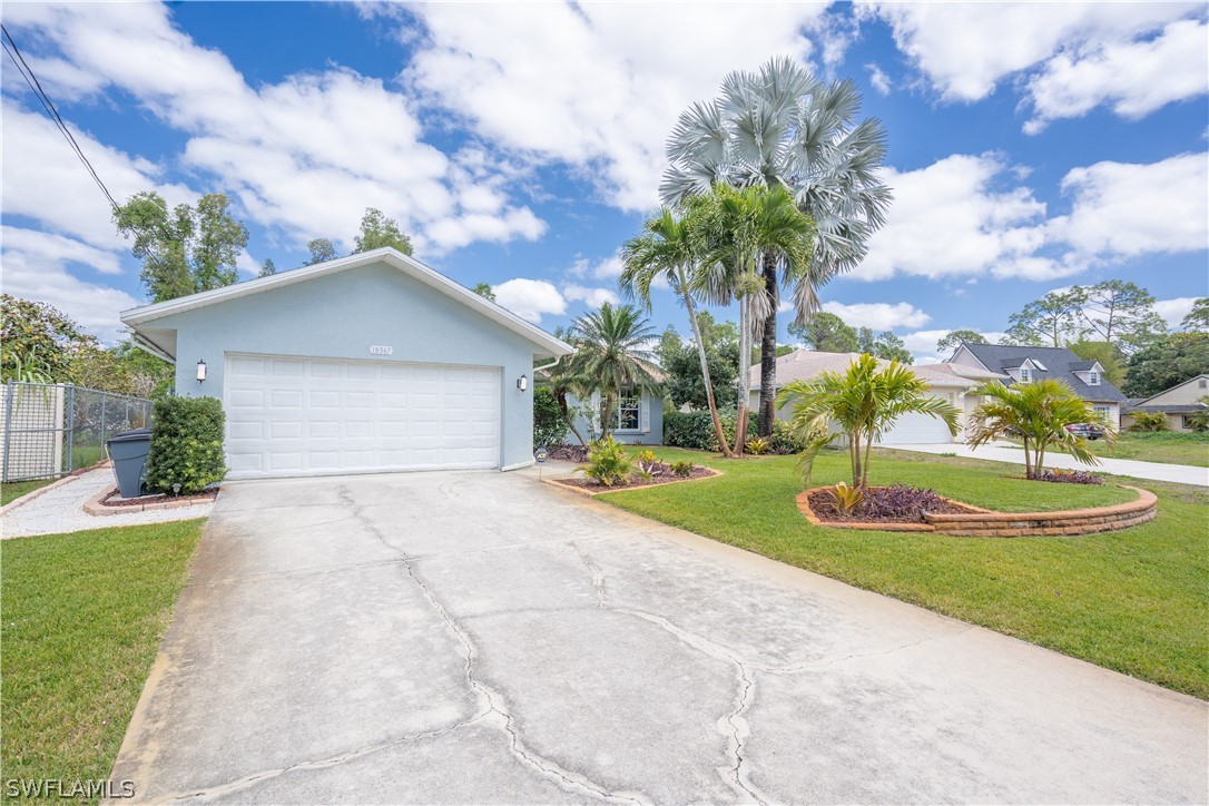 18367 Tulip Road Fort Myers, FL 33967 - Photo 1 of 13 a front view of a house with a yard and garage