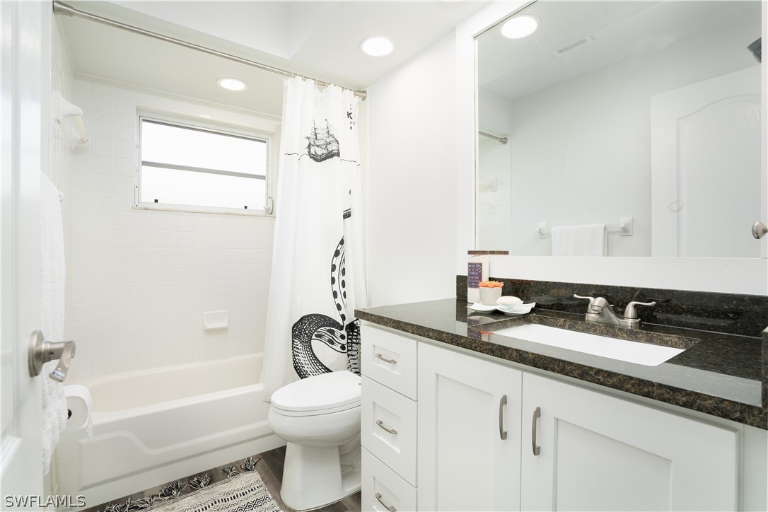 18367 Tulip Road Fort Myers, FL 33967 - Photo 12 of 13 a bathroom with a granite countertop sink a toilet and a bathtub