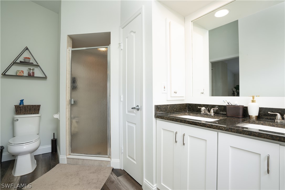 18367 Tulip Road Fort Myers, FL 33967 - Photo 9 of 13 a bathroom with a granite countertop sink a toilet and a mirror