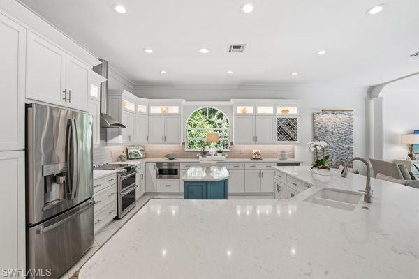 2026 Merlin Court Naples, FL 34105 - Photo 11 of 43 a kitchen with stainless steel appliances a dining table chairs stove and refrigerator