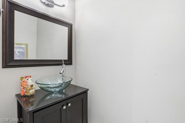 2026 Merlin Court Naples, FL 34105 - Photo 19 of 43 a bathroom with a granite countertop sink and a mirror