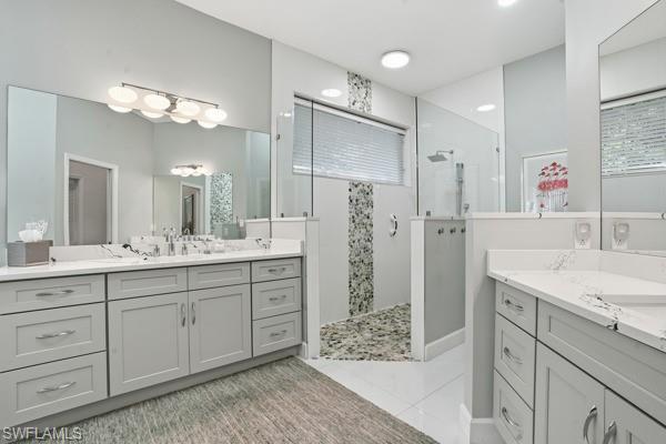 2026 Merlin Court Naples, FL 34105 - Photo 24 of 43 a spacious bathroom with double sink and a mirror