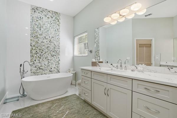 2026 Merlin Court Naples, FL 34105 - Photo 25 of 43 a bathroom with a bathtub sink and mirror