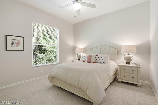 2026 Merlin Court Naples, FL 34105 - Photo 29 of 43 a bedroom with a bed and a chandelier