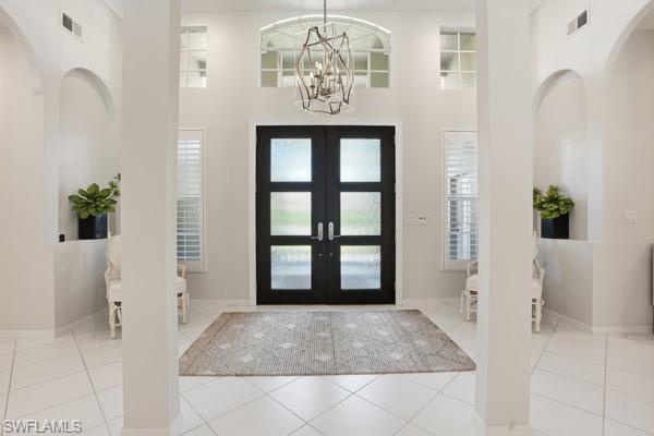 2026 Merlin Court Naples, FL 34105 - Photo 4 of 43 a view of entrance with wooden floor and a chandelier
