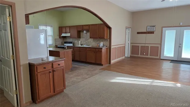 a kitchen with stainless steel appliances granite countertop a stove a sink and a refrigerator