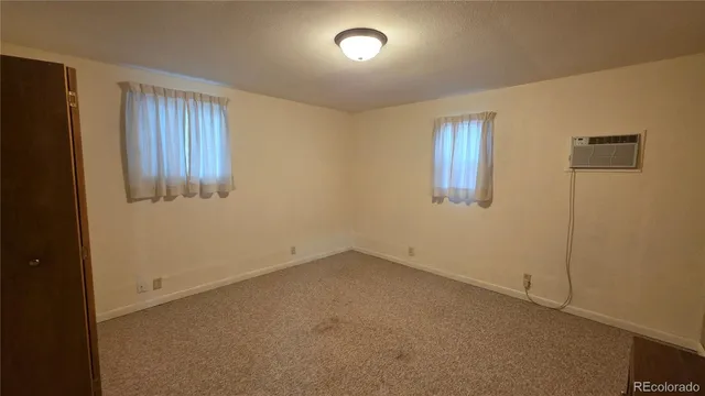 a view of an empty room with closet and mirror